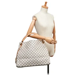 The Artsy MM features a damier azur canvas body, a rolled vachetta handle, an open top, and interior zip and slip pockets. - Avvenice
